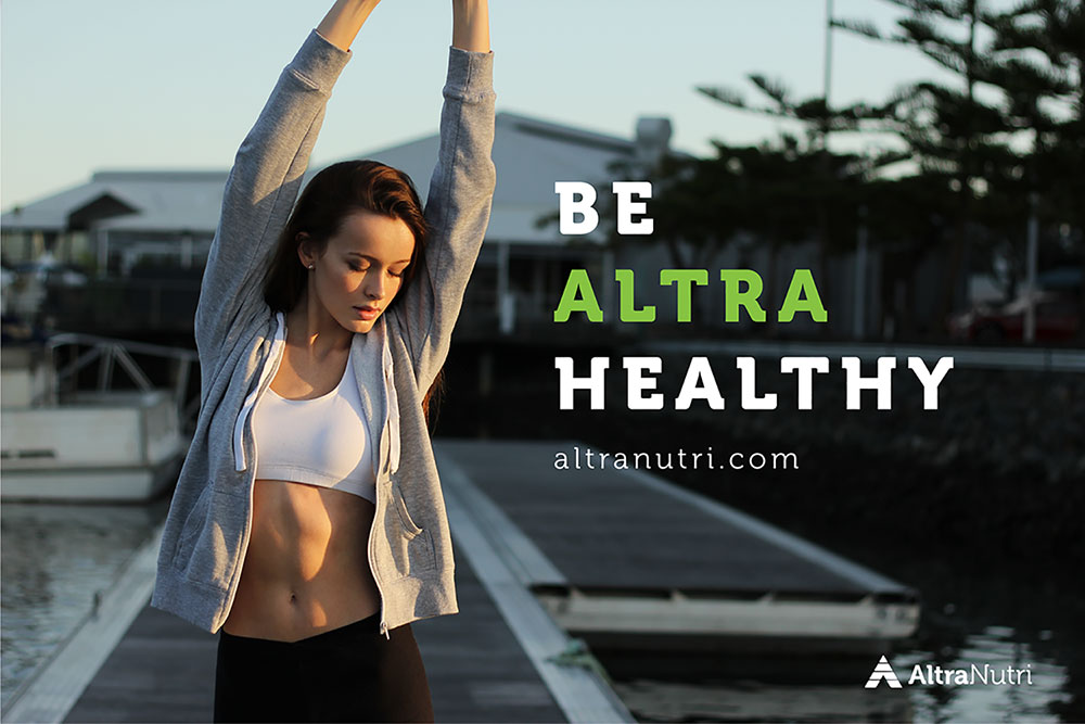 A woman in athletic wear stretches outdoors on a dock near water, with the text Be Altra Healthy and the website altranutri.com displayed. The AltraNutri logo is in the lower right corner.