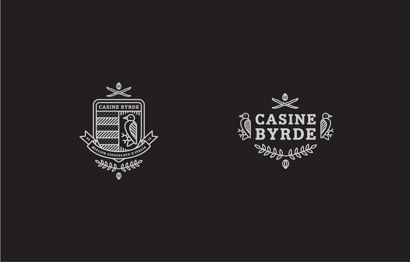 Two white outlined logos on a black background for Casine Byrde. The left logo features a shield with books, a bird, and a ribbon. The right logo shows two birds flanking the text, with branches and a seed below.