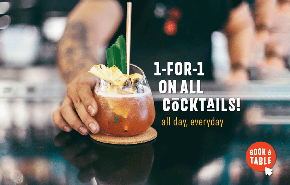 A hand sets a tropical cocktail garnished with pineapple on a bar. Text reads 1-FOR-1 ON ALL COCKTAILS! all day, everyday. A red button in the corner says BOOK A TABLE.