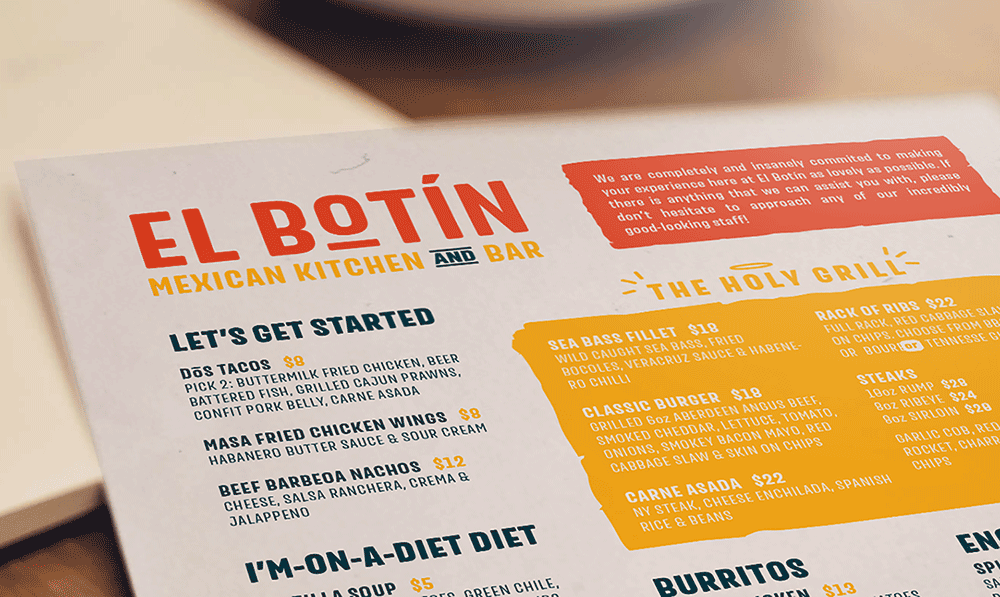 A close-up of a restaurant menu for El Botín Mexican Kitchen and Bar designed by Sandra Tay, featuring colorful text and sections like Let’s Get Started, The Holy Grill, and menu items including tacos, wings, nachos, burgers, and fish.