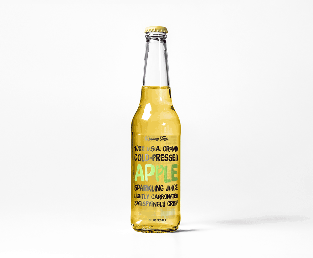 A clear glass bottle of apple sparkling juice with a yellow liquid inside. The label reads 100% U.S.A. Grown Cold-Pressed Apple Sparkling Juice in colorful text on a plain white background.