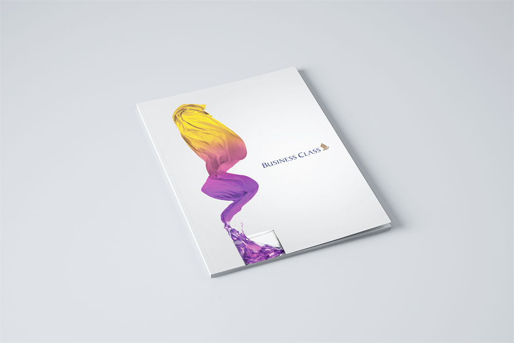 A menu brochure for SIA designed by Sandra Tay with a white cover featuring swirling yellow and purple paint forming a silhouette, with the words Business Class and a gold emblem on a minimal, light gray background.