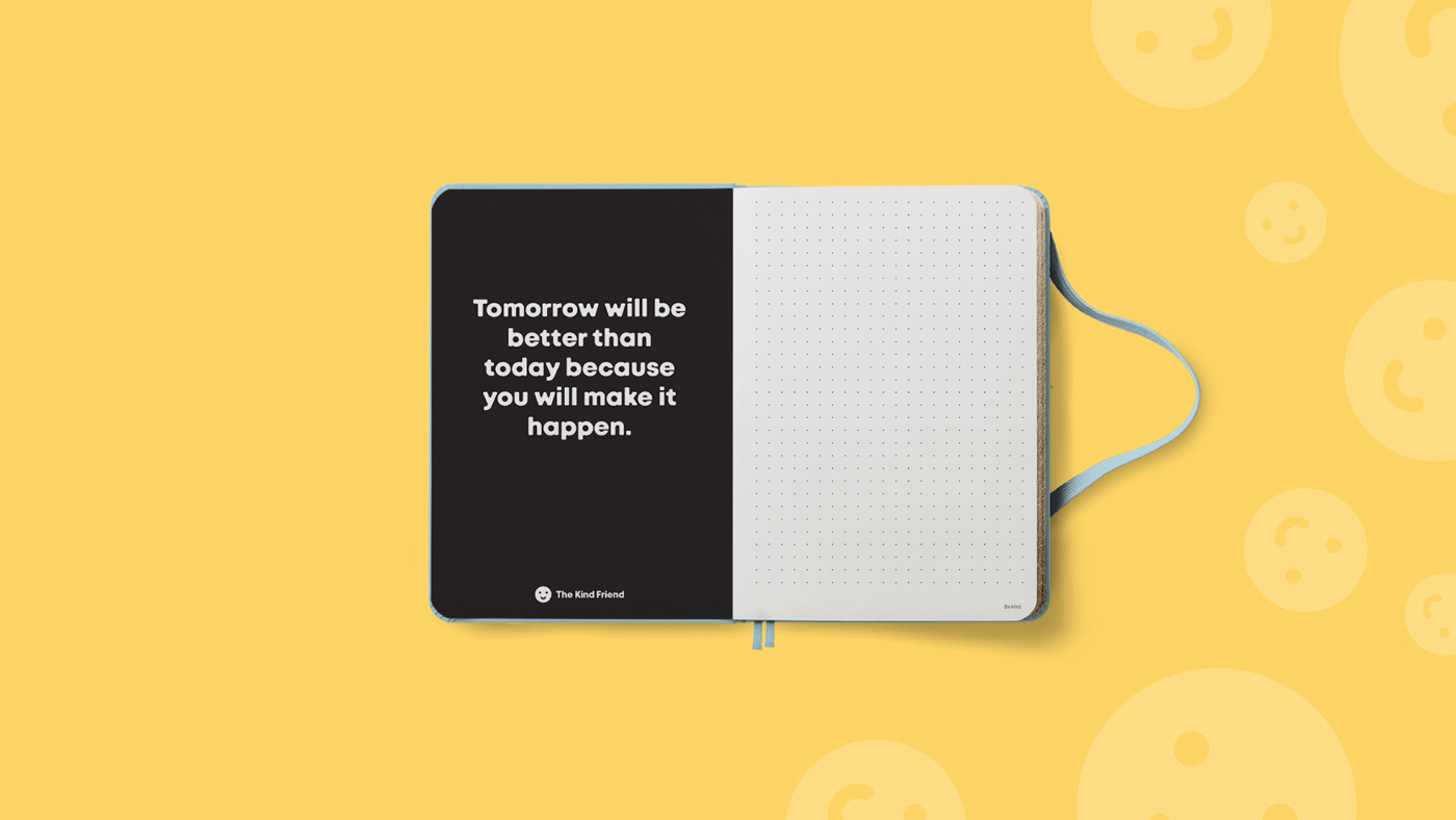 An open notebook on a yellow background. The left page is black with the white text: Tomorrow will be better than today because you will make it happen. The right page is blank and dotted, with a blue elastic band visible.
