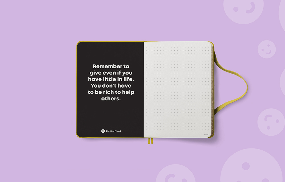 An open notebook with a yellow ribbon on a lavender background. The left page is black with white text: Remember to give even if you have little in life. You dont have to be rich to help others. The right page is blank and dotted.
