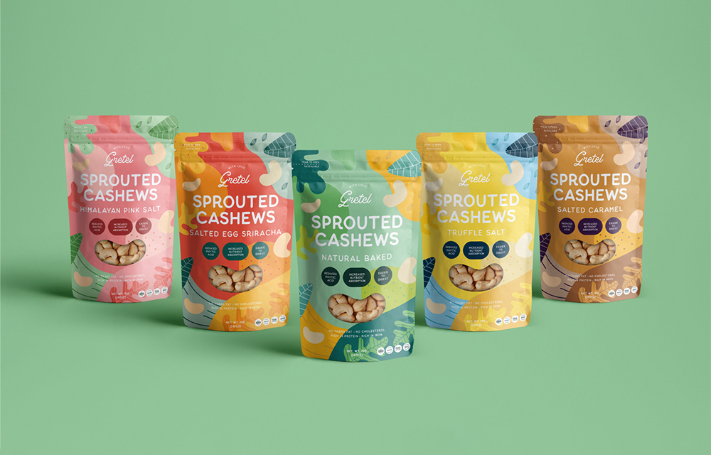 Five colorful packets of Sprouted Cashews designed by Sandra Tay, feature flavors like Himalayan Pink Salt, Salted Egg Sriracha, and Truffle Salt—displayed on a green surface with a vibrant green background.