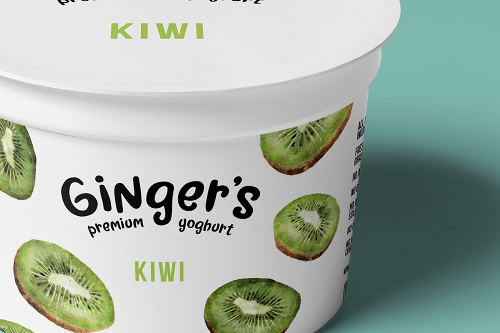 A white yogurt container labeled Ginger’s premium yoghurt with images of sliced kiwis on it. The word KIWI appears on both the lid and the side of the container against a light blue background.